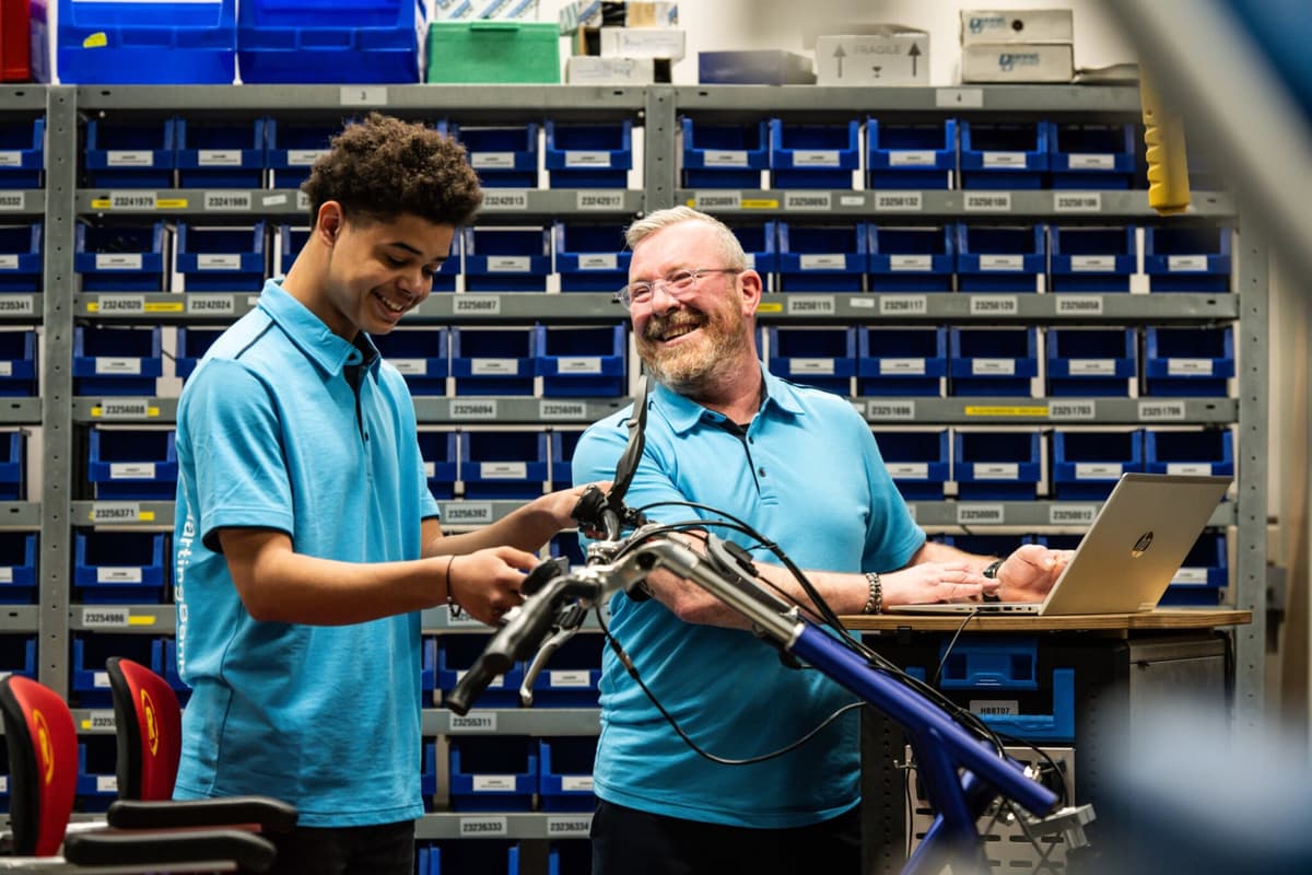 Foto van twee mannen die een vrolijk moment delen tijdens het werk aan een duofiets